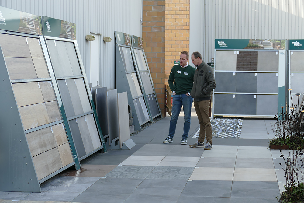 2 mensen die Tuinvisie producten op displays aan het bewonderen zijn in de buitenlucht.